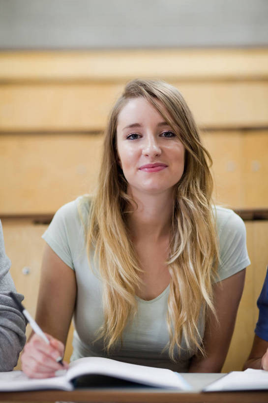 西方人,一个人,学校,坐,笑,微笑,竖图,室内,白天,正面,桌子,书籍,欧洲,欧洲人,仅一个年轻女性,仅一个女性,仅一个人,握,服装,笔,办公用品,记事本,拿,拿着,注视,休闲装,书桌,校园,水笔,文具,衣服,本子,笔记本,课桌,学习用品,书本,观察,看,休闲,教室,休闲服,握着,服饰,观看,文具用品,察看,课堂,阶梯教室,关注,年轻女性,女人,女性,白种人,书,图书,坐着,半身,彩图