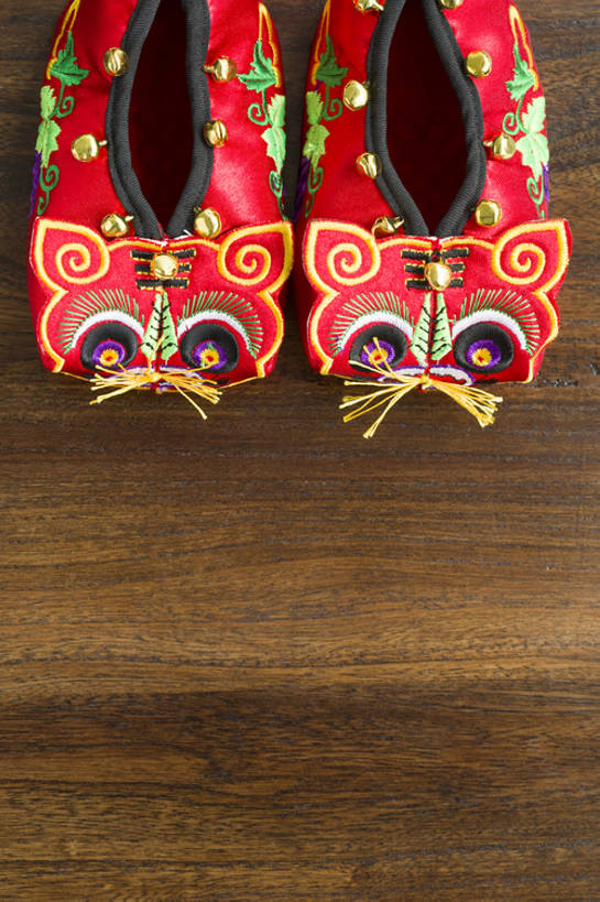 无人,竖图,俯视,特写,留白,婴儿服装,纯洁,运气,复古,桌子,静物,鞋子,刺绣,北京,中国,春节,新年,亚洲,花纹,风俗,节日,庆祝,鲜艳,图案,冬天,艺术品,一对,古典,传统,两个,红色,婴儿鞋,工艺品,精神,可爱,童年,童趣,摄影,虎头鞋,褐色背景,婴儿用品,仪式,风格,中国文化,手艺,典礼,古典风格,童真,东亚,烂漫,无邪,制度,美术工艺,天真,彩图,高角度拍摄,影棚拍摄,婴儿服,传统文化,襁褓,bj175